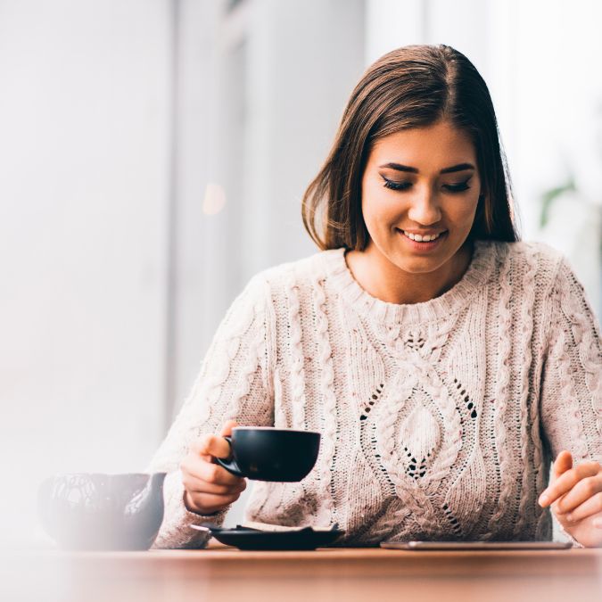 woman happy drinking tea whilst working